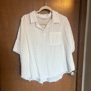 white top with buttons and a raw hem
